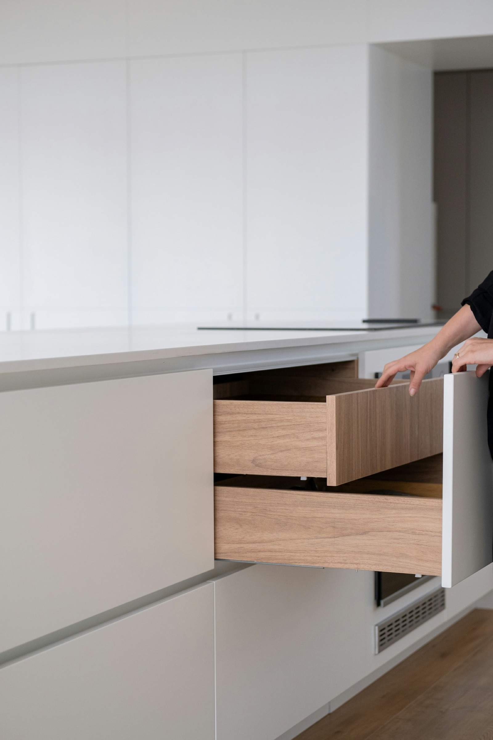 Hand opening a fitted kitchen drawer