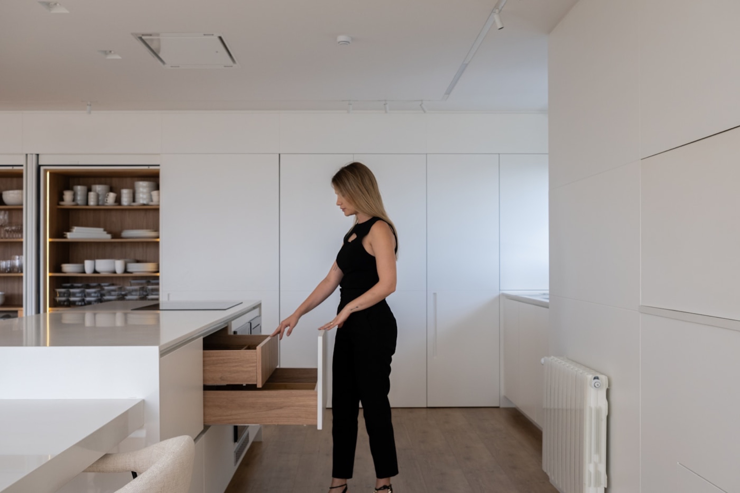 An undercounter drawer opens beside shelves holding everyday dishes