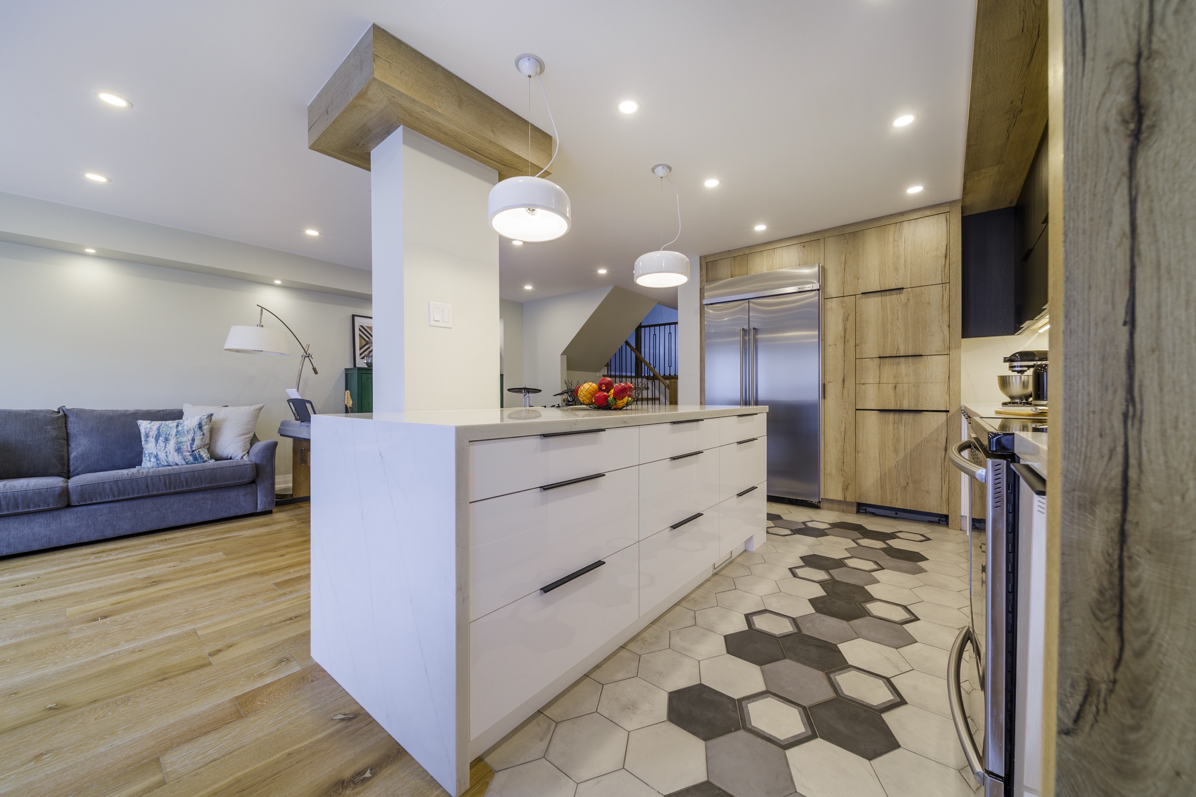 Open kitchen with dark upper cabinets, light lower cabinets and wood-grain panels