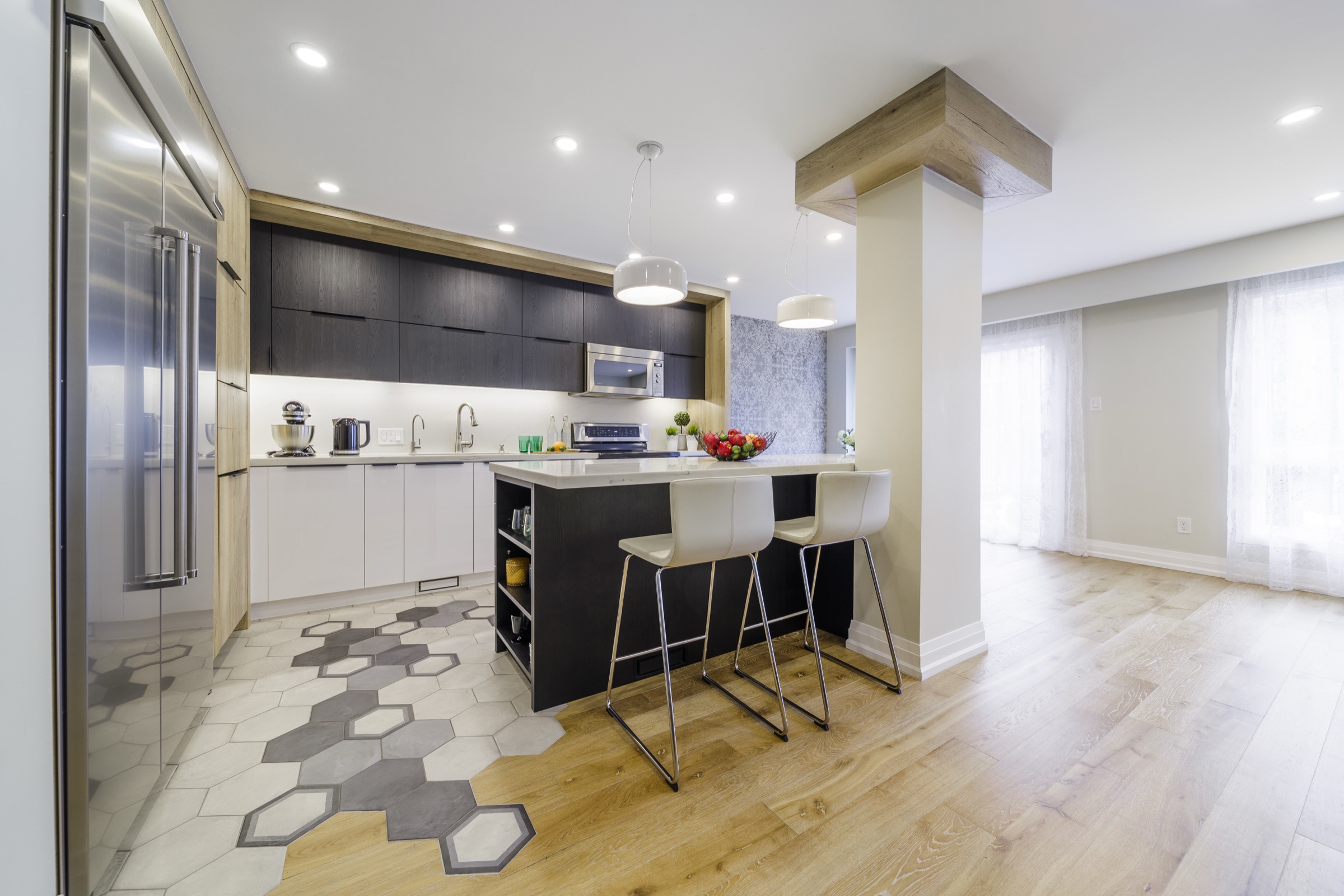 Open kitchen with dark upper cabinets, light lower cabinets and wood-grain panels