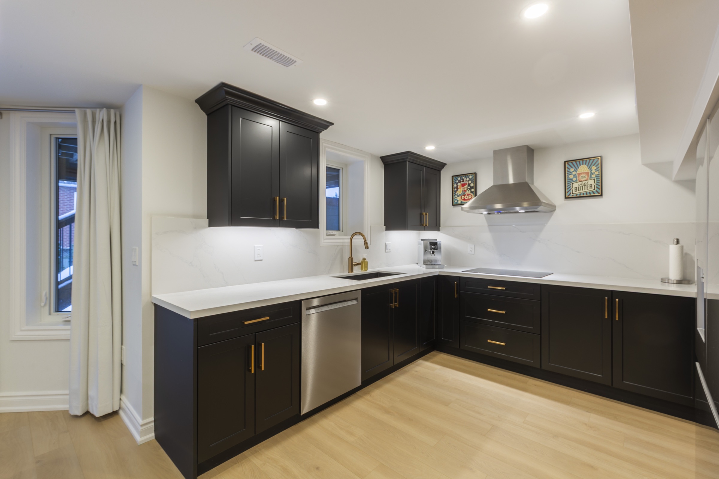 Completed dark framed kitchen with warm hardware
