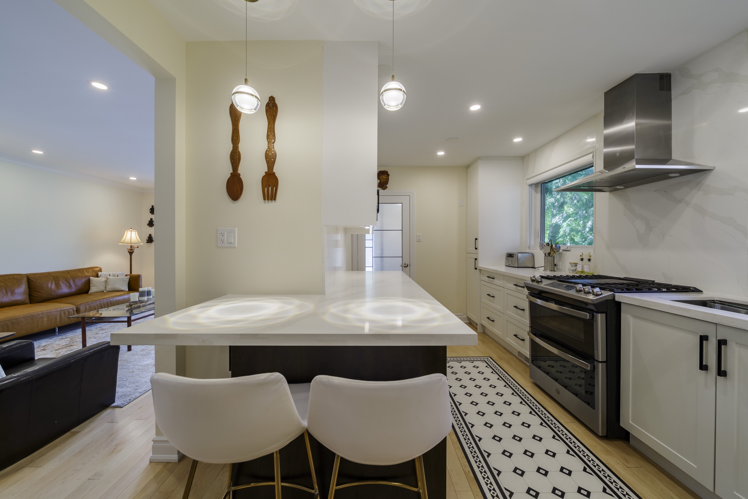 Kitchen island facing a range, hood and fitted cabinetry