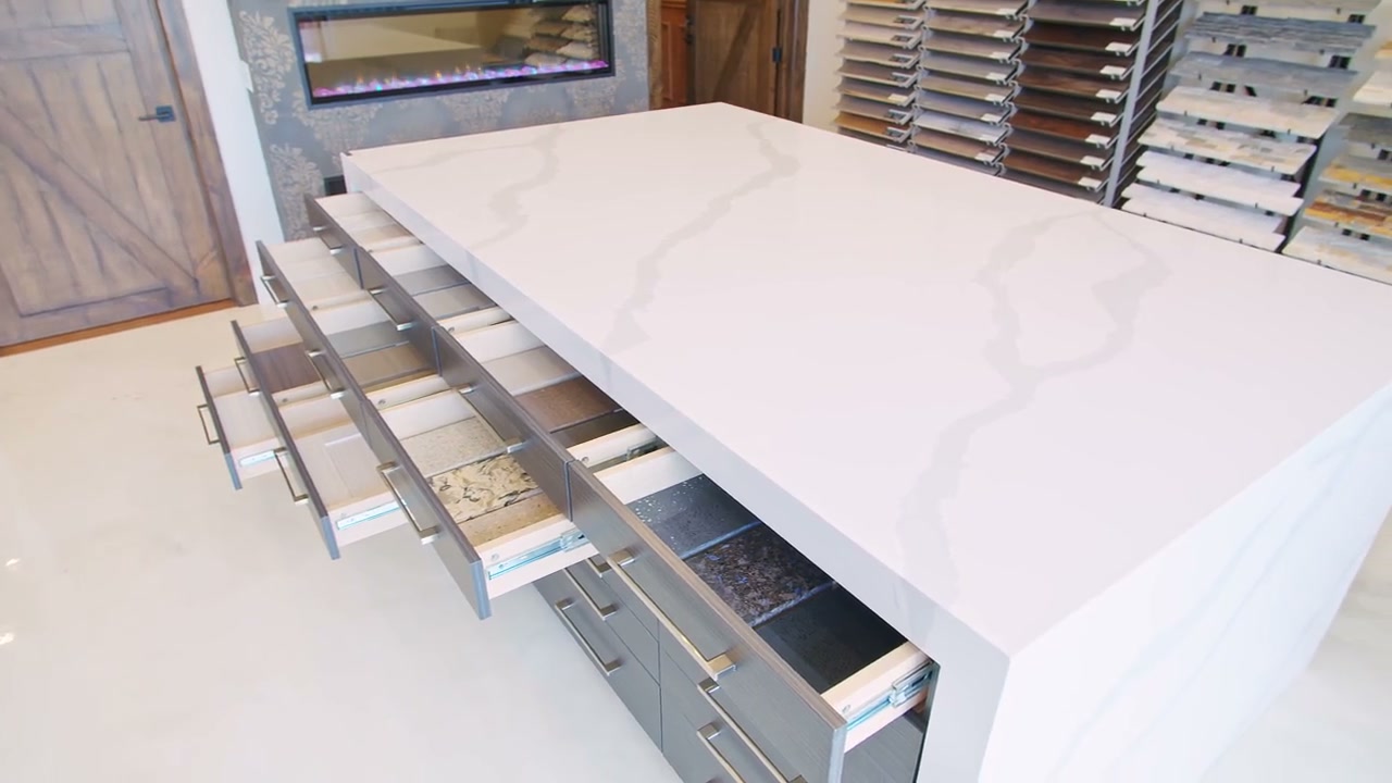 Surface samples in open drawers beneath a pale worktop and its edge
